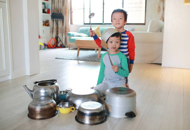 istock Two brother playing on floor with pots and pans 868866994