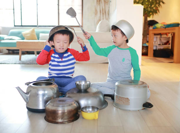 istock Two brother playing on floor with pots and pans 868867028