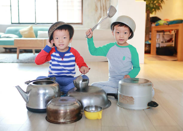 istock Two brother playing on floor with pots and pans 868867096