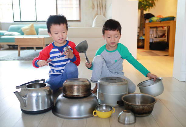 istock Two brother playing on floor with pots and pans 868869224