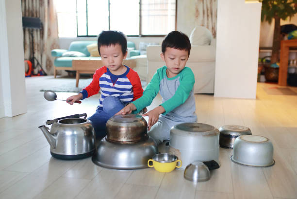istock Two brother playing on floor with pots and pans 868871288