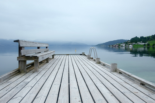 Misty morning on Norheimsund village. Wooden pier on hardangerfjord, Norway, Europe