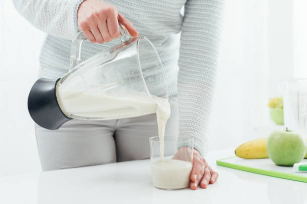 istock Woman pouring a smoothie into a glass 868872768