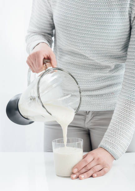 istock Woman pouring a smoothie into a glass 868872940