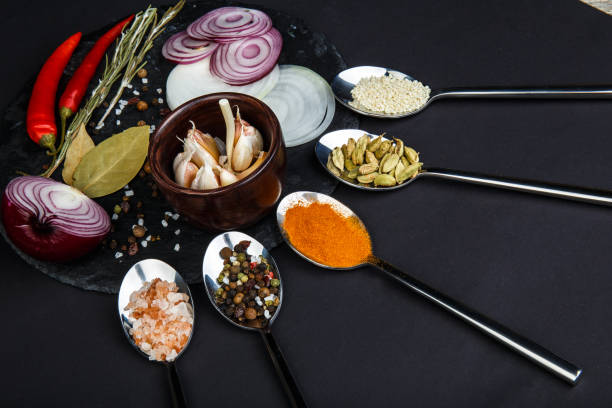 istock A board with onion, garlic, bay leaf, pepper and salt beside which lie spoons with various spices. 868873042