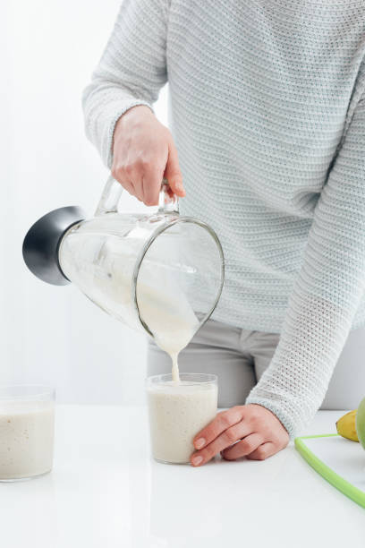 istock Woman pouring a smoothie into a glass 868873060
