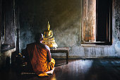 istock A monk is worshiping and meditating in front of the golden Buddha as part of Buddhist activities.Focus on the Buddha 868876432