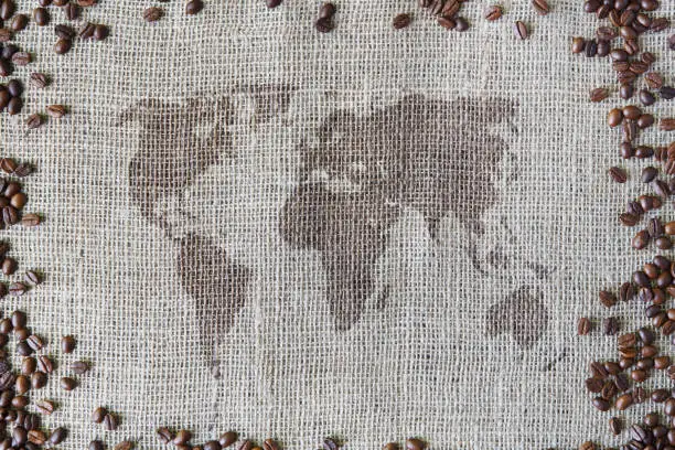 Photo of Burlap texture with coffee beans border and world map
