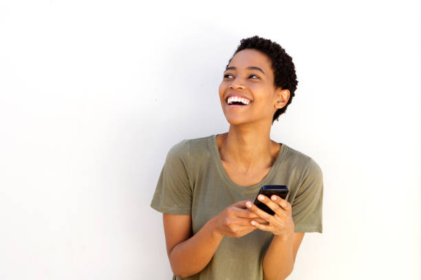 beautiful young black woman laughing with cellphone stock photo