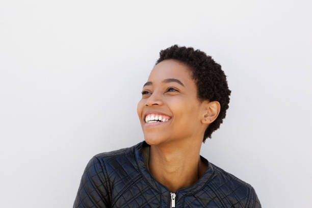 istock attractive young black woman laughing against white wall 868888244