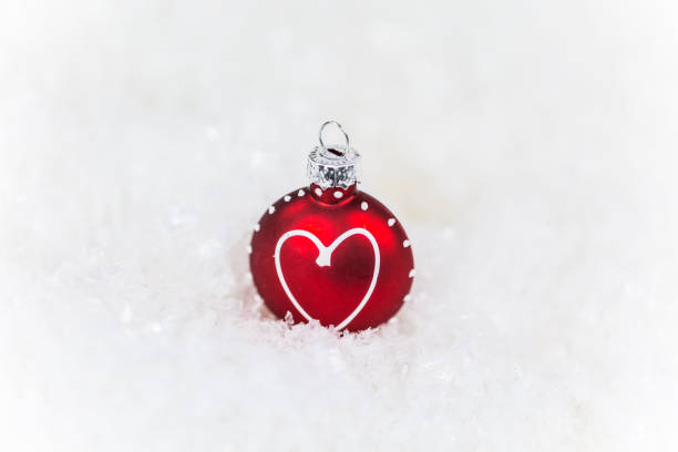istock red Christmas tree ball with heart, lying in snow 868891810