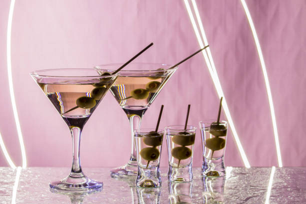 istock Martini with olives standing on the bar and outlined by a bright light. Club atmosphere 868896882
