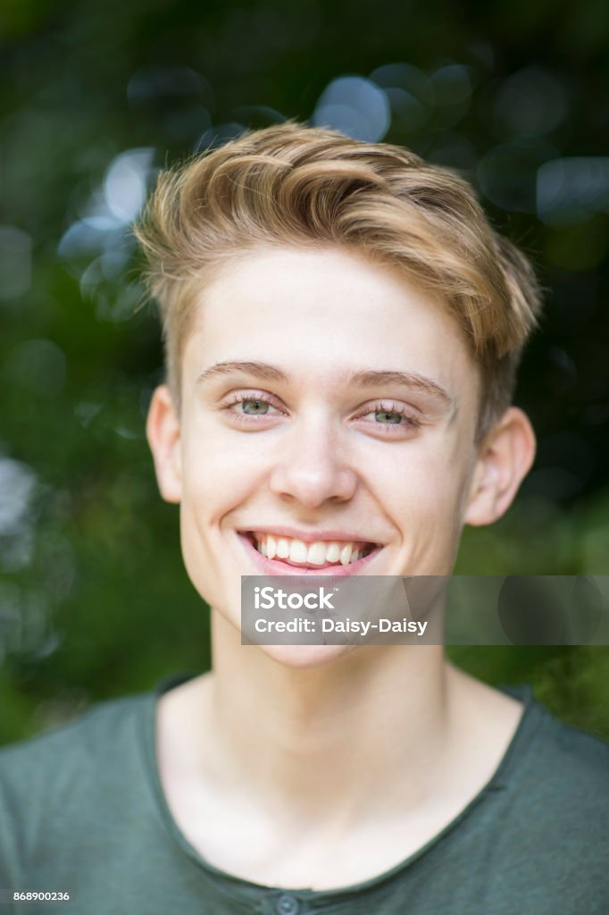 Retrato de adolescente feliz sentado al aire libre - Foto de stock de Chicos adolescentes libre de derechos