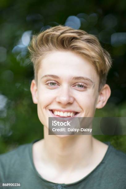Portrait Of Happy Teenage Boy Sitting Outdoors Stock Photo - Download Image Now - Teenage Boys, Teenager, Portrait