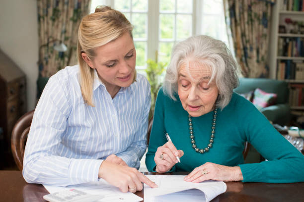 istock Woman Helping Senior Neighbor With Paperwork 868904530