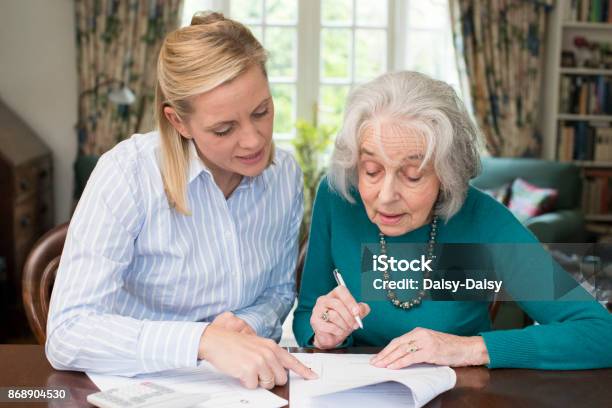 Woman Helping Senior Neighbor With Paperwork Stock Photo - Download Image Now - Senior Adult, General Power Of Attorney, Assistance