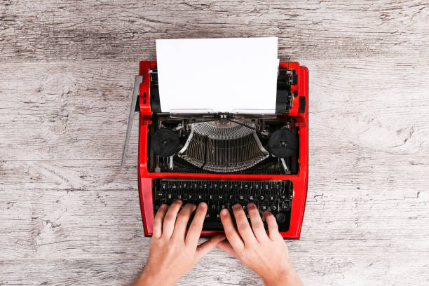 istock Hands of a man typing on a red typewriter maschine 868919466