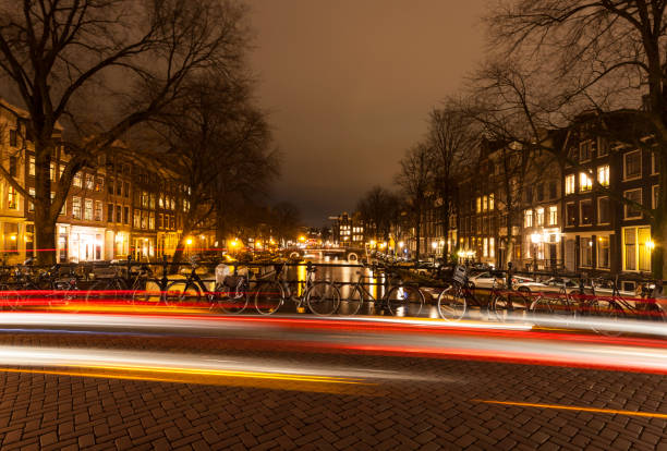 istock Amsterdam canal bridge with light trails at night 868920614