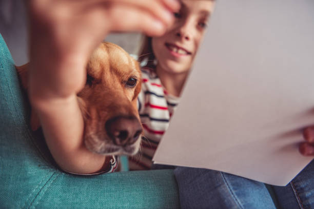 istock Girl with dog writing wish list on sofa 868923300