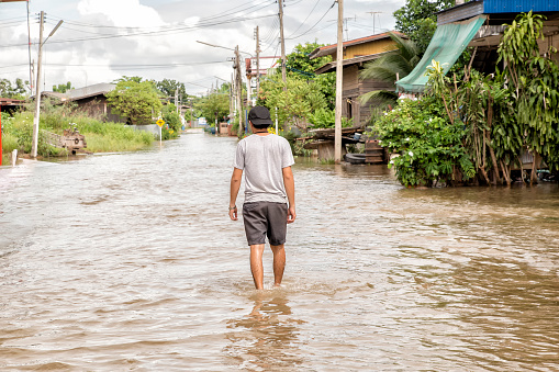 man walking through a flood on street
