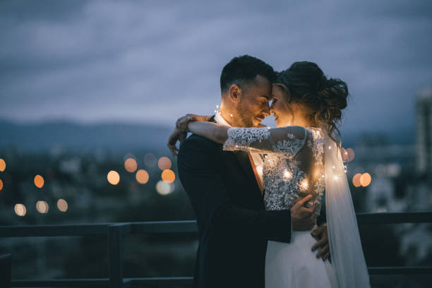 Bride and Groom enjoying in their love Romantic newlyde couple standing on the roof top in the city in the night wedding dress photos stock pictures, royalty-free photos & images