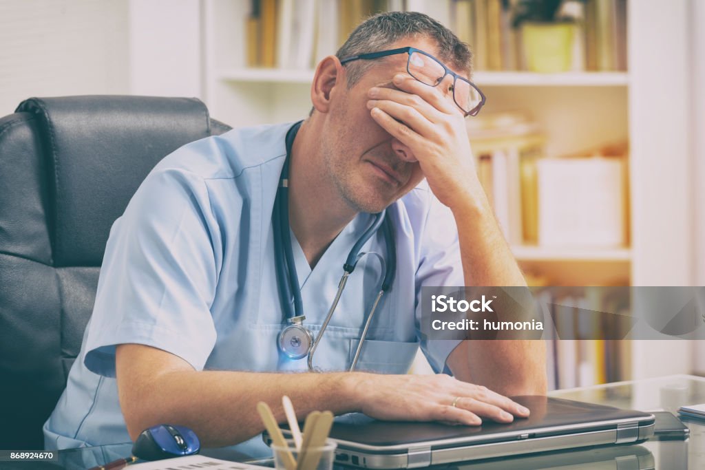 Con exceso de trabajo médico en su oficina - Foto de stock de Doctor libre de derechos