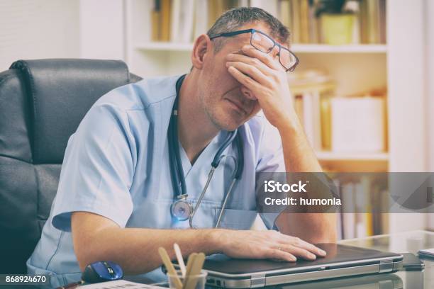 Con Exceso De Trabajo Médico En Su Oficina Foto de stock y más banco de imágenes de Doctor - Doctor, Estrés, Cansado