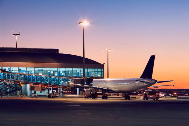 Airport at the colorful sunset Preparation of the airplane before flight. Airport at the colorful sunset. passenger boarding bridge stock pictures, royalty-free photos & images