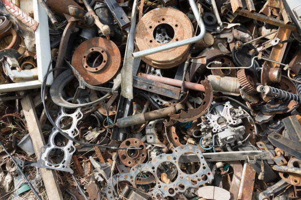 vecchie parti arruggine corrose nel parco rottame dell'auto. riciclaggio auto. le parti dei macchinari di demolizione attendono di essere riutilizzate o di essere parte per la riparazione. - metal waste foto e immagini stock