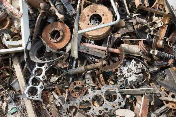Photo of Old rusty corroded car parts in car scrapyard. Car recycling.Wrecking Machinery Parts wait for reused or to be a part for repair.