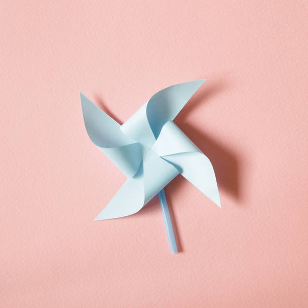 Blue paper pinwheel on pink background