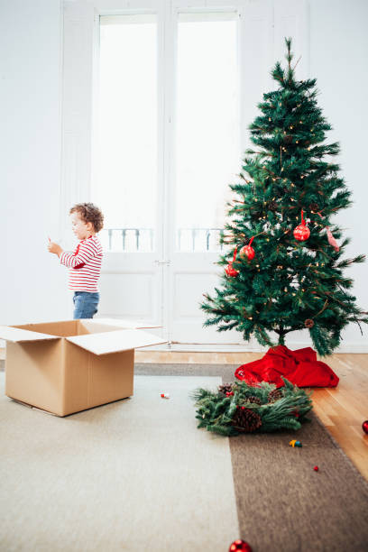 geschwister, schmücken den weihnachtsbaum - christmas decoration photography themes christmas ornament stock-fotos und bilder