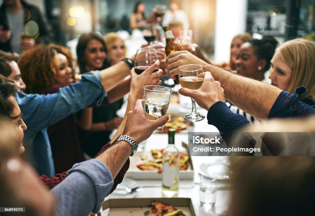 Here's to tonight Cropped shot of a group of young friends toasting during a dinner party at a restaurant Restaurant Stock Photo