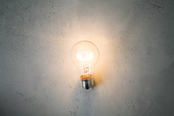 istock Vintage incandescent bulb on concrete background 868945090