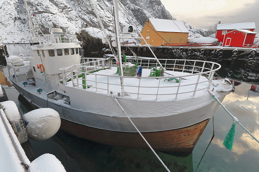 Old wooden fishing boat moored-snow covered harbor-Nusfjord fishing village. Flakstadoya-Lofoten-Norway.0495