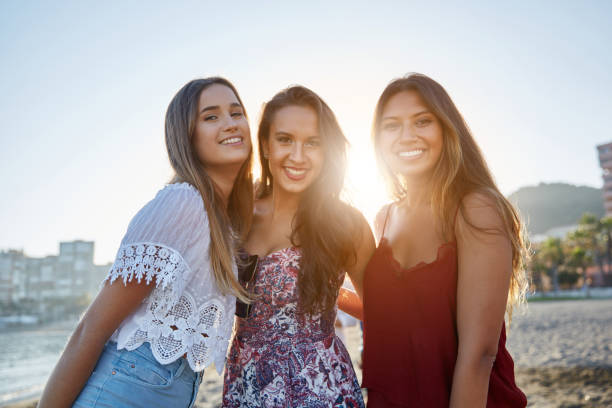 istock Three pretty girls standing on beach in sunlight 868945730