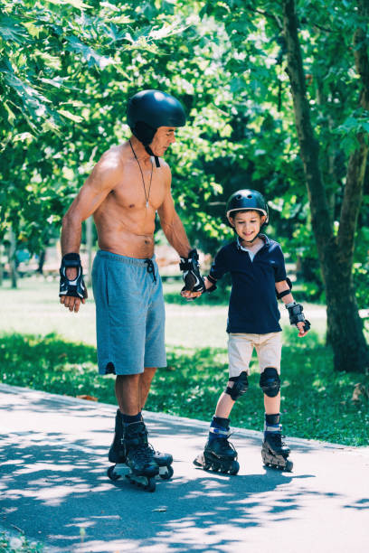 istock Grandfather and grandson roller skating, holding hands 868963090