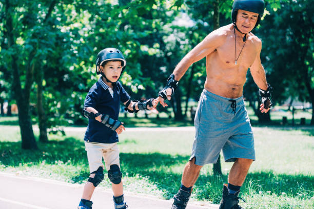 istock Grandfather and grandson roller skating, holding hands 868965678
