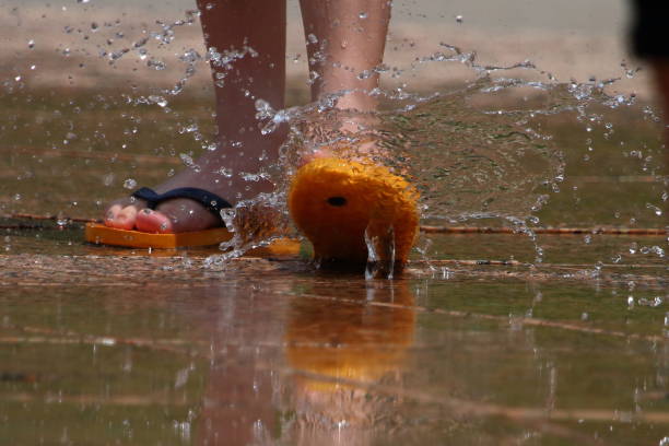 On a summer afternoon, children were playing in a fountain in the park.