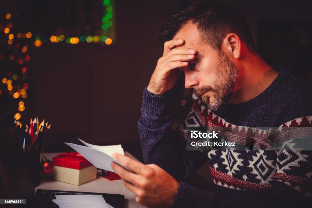 Worried Men cheeking his mail late night Worried men cheeking his mail late night in home office during christmas holidays Christmas Stock Photo