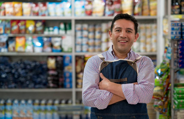 Portrait of a man working at a grocery store Portrait of a Latin American man working at a grocery store and looking at the camera smiling hispanic guy stock pictures, royalty-free photos & images