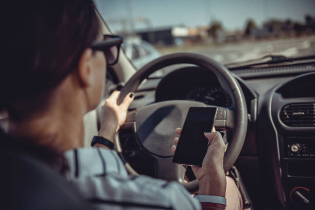 istock Woman driving car and using smart phone 868991382