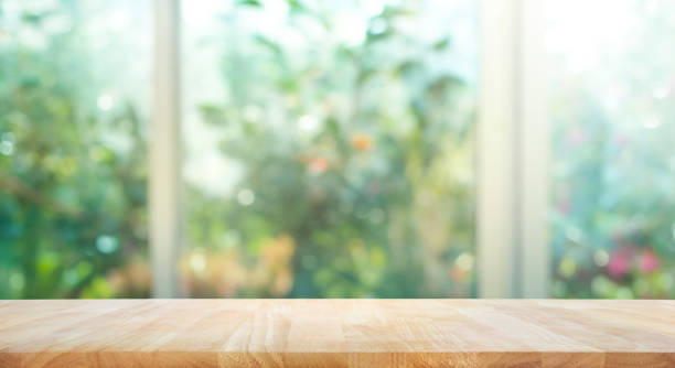 деревянный стол на размытие окна с садом цветок фон - показ сад стоковые фото и изображения