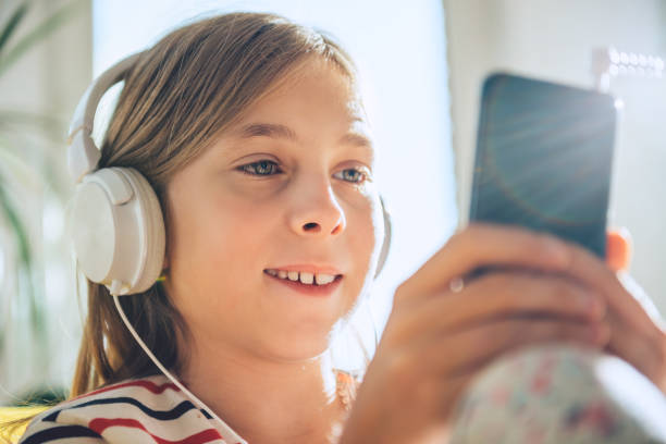 istock Little girl with headphones using smart phone 869003612