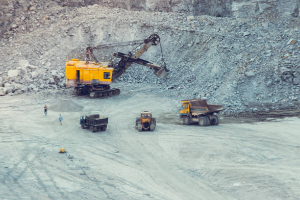 istock huge excavator, truck and man standing next on granite quarry 869004452