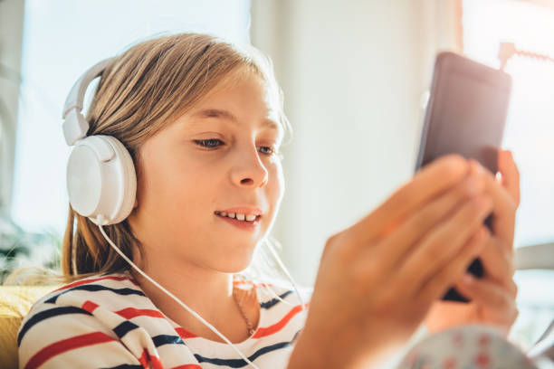 istock Little girl with headphones using smart phone 869004822