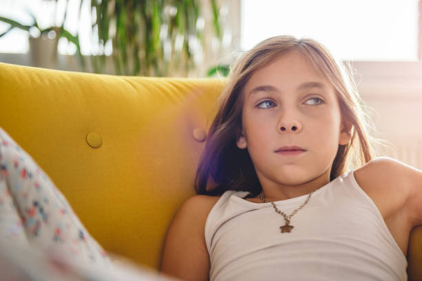 istock Little girl sitting on sofa and watching TV 869004920
