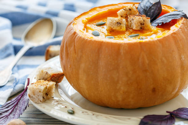 istock Pumpkin soup with croutons in a pumpkin closeup. 869005462