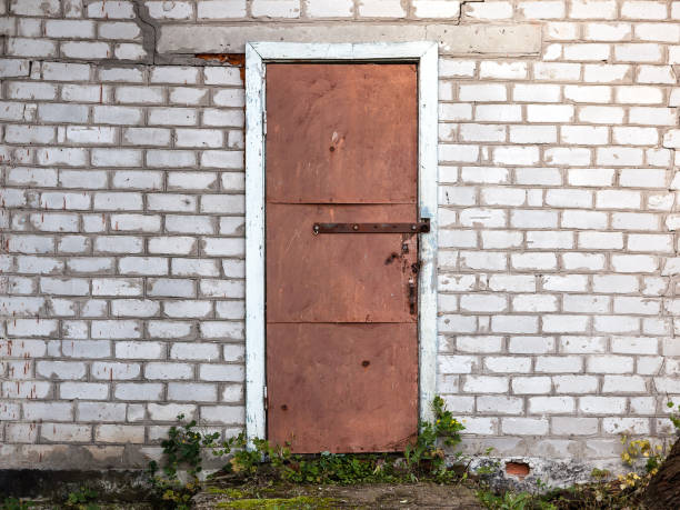 istock Old weathered barn door and brick wall. 869005476