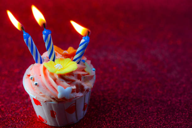 istock Birthday cupcake with candles on color background 869008136
